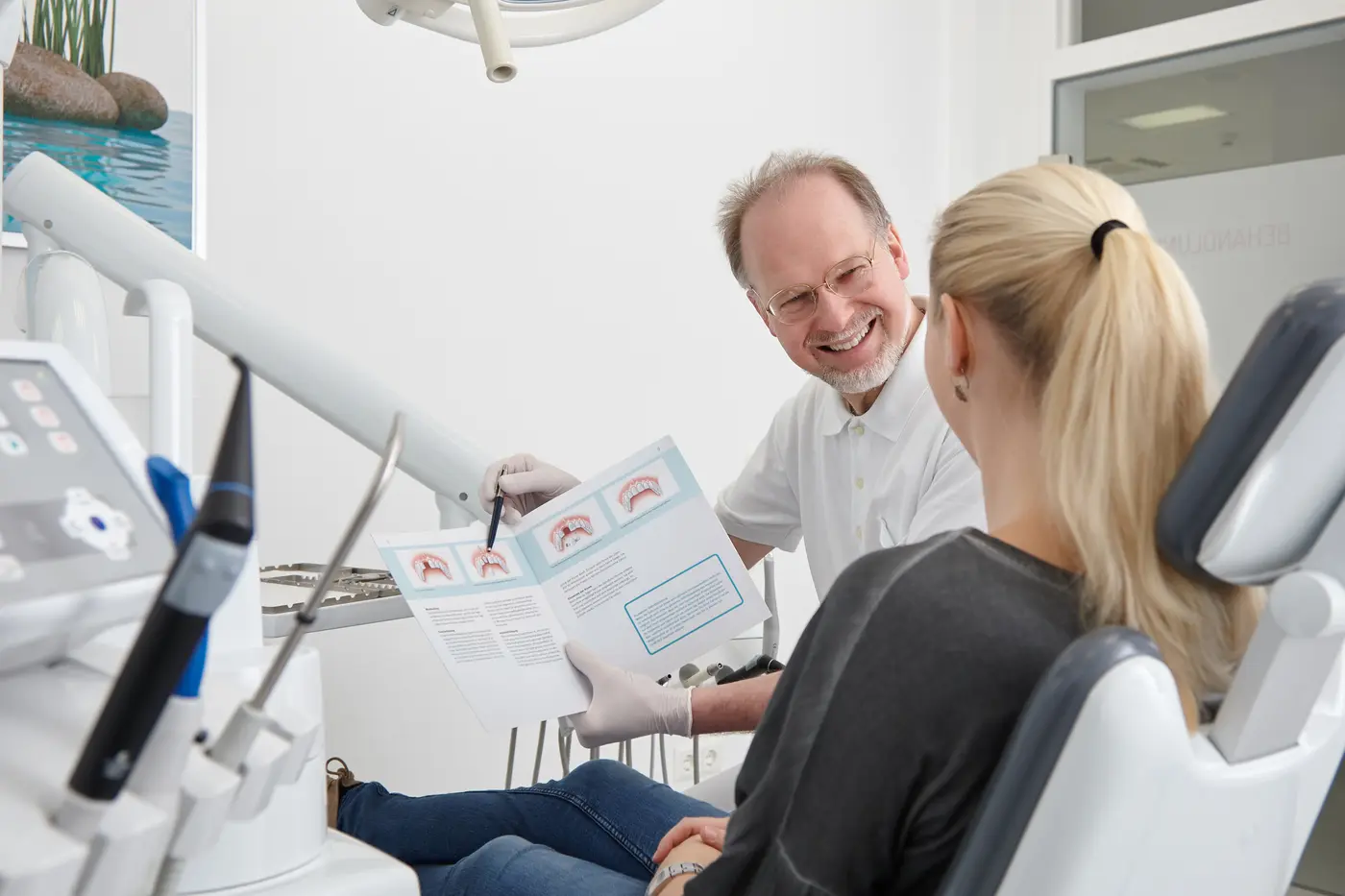 Patientenberatung mit Anschauungsmaterial am Behandlungsstuhl